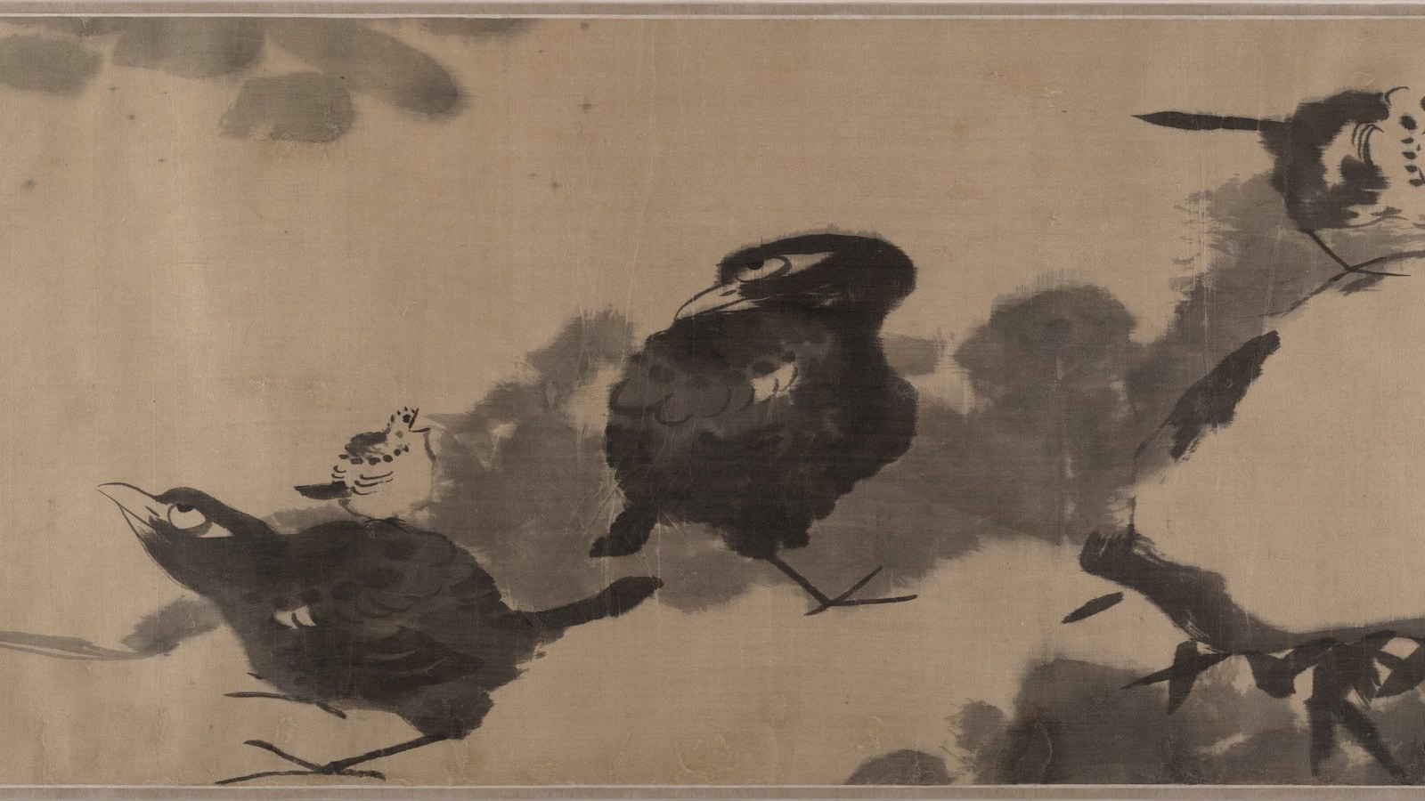 Ink painting of birds among lotus stems by Bada Shanren: a few dark birds rendered in a handful of wet brushstrokes, perched and glancing upward with the eye set high in the head, surrounded by large areas of untouched silk.