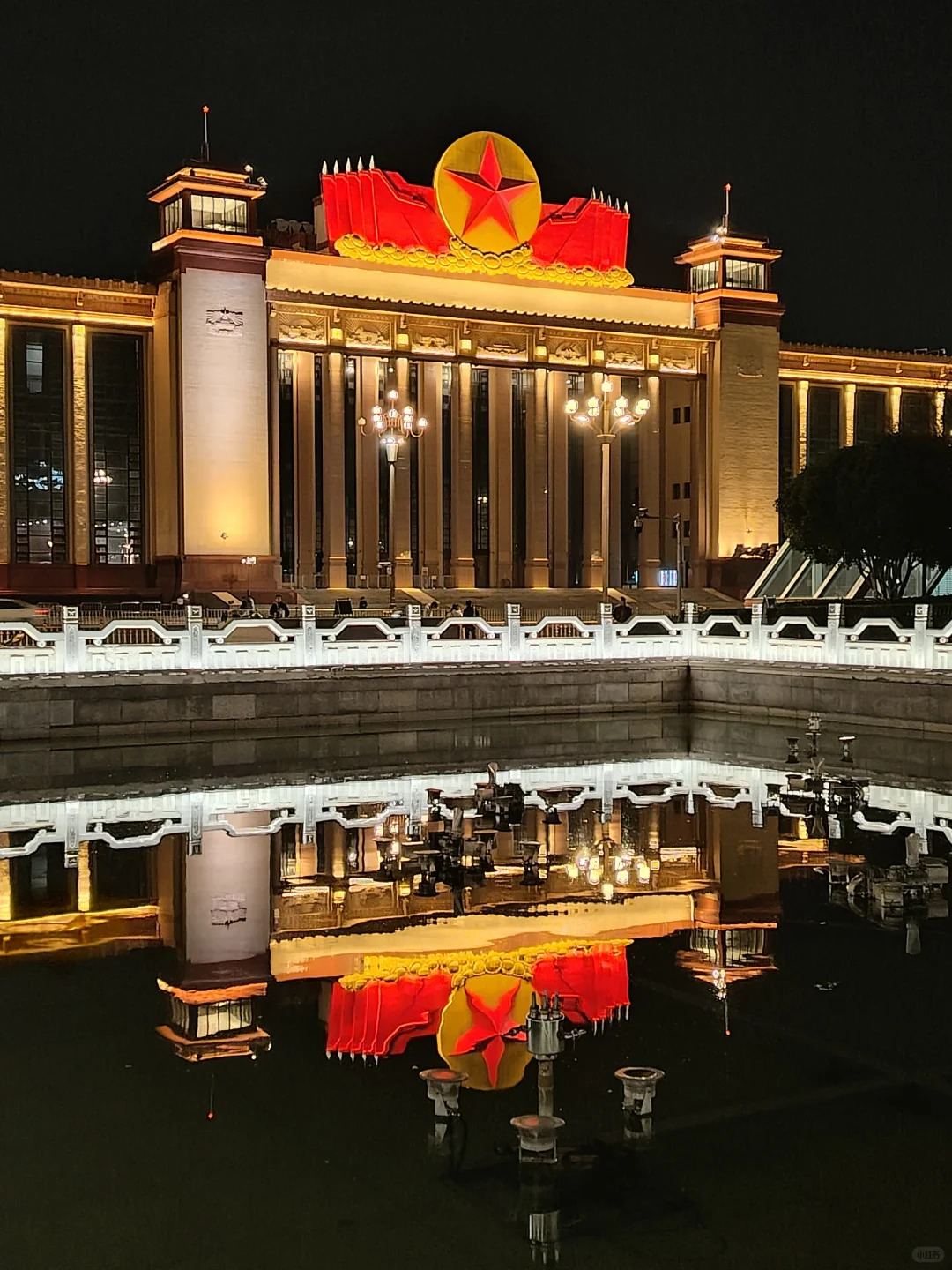 The former Long Live Hall in Nanchang, now the Jiangxi Provincial Art Museum, lit at night with its giant red star and reflected in the canal