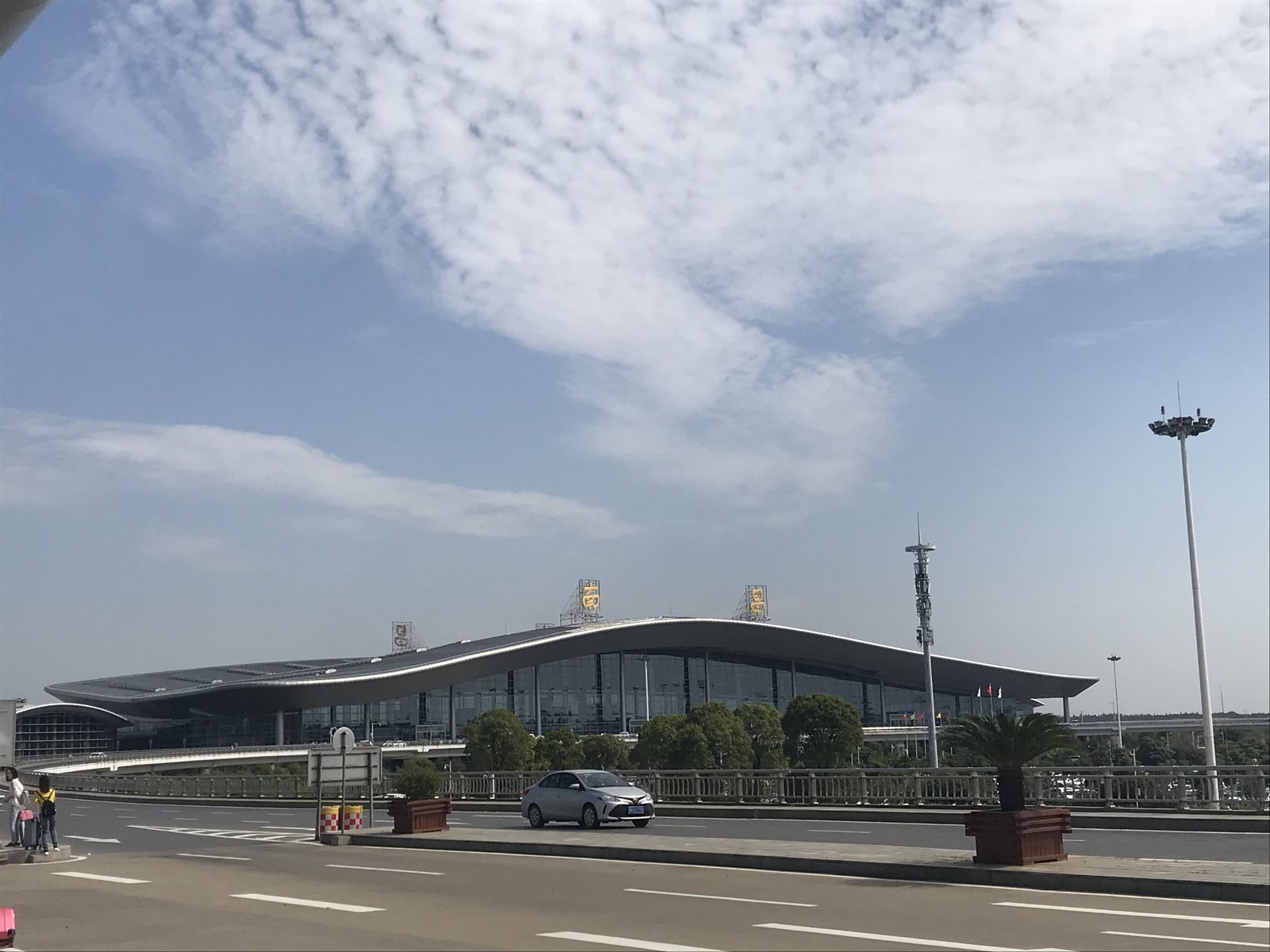 Nanchang Changbei International Airport Terminal 2 seen from outside, its long curved wing-like roofline under a blue sky