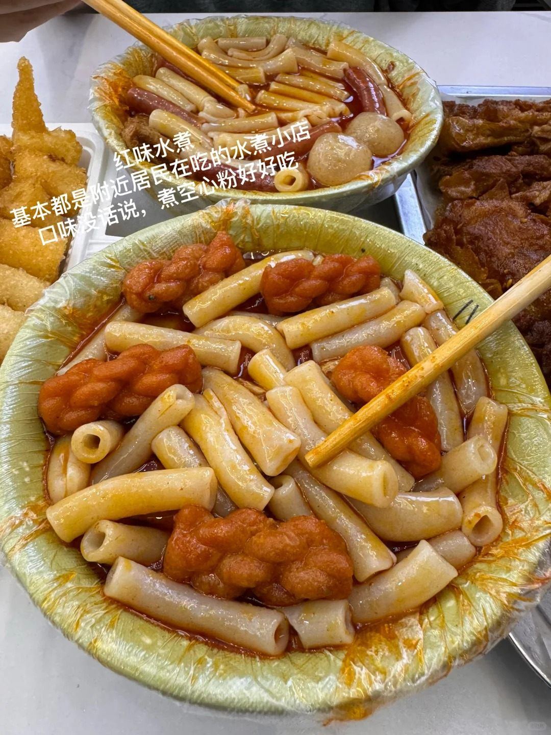 Bowl of Nanchang shuizhu boiled snacks with rice cake sticks and fish balls in red chilli broth