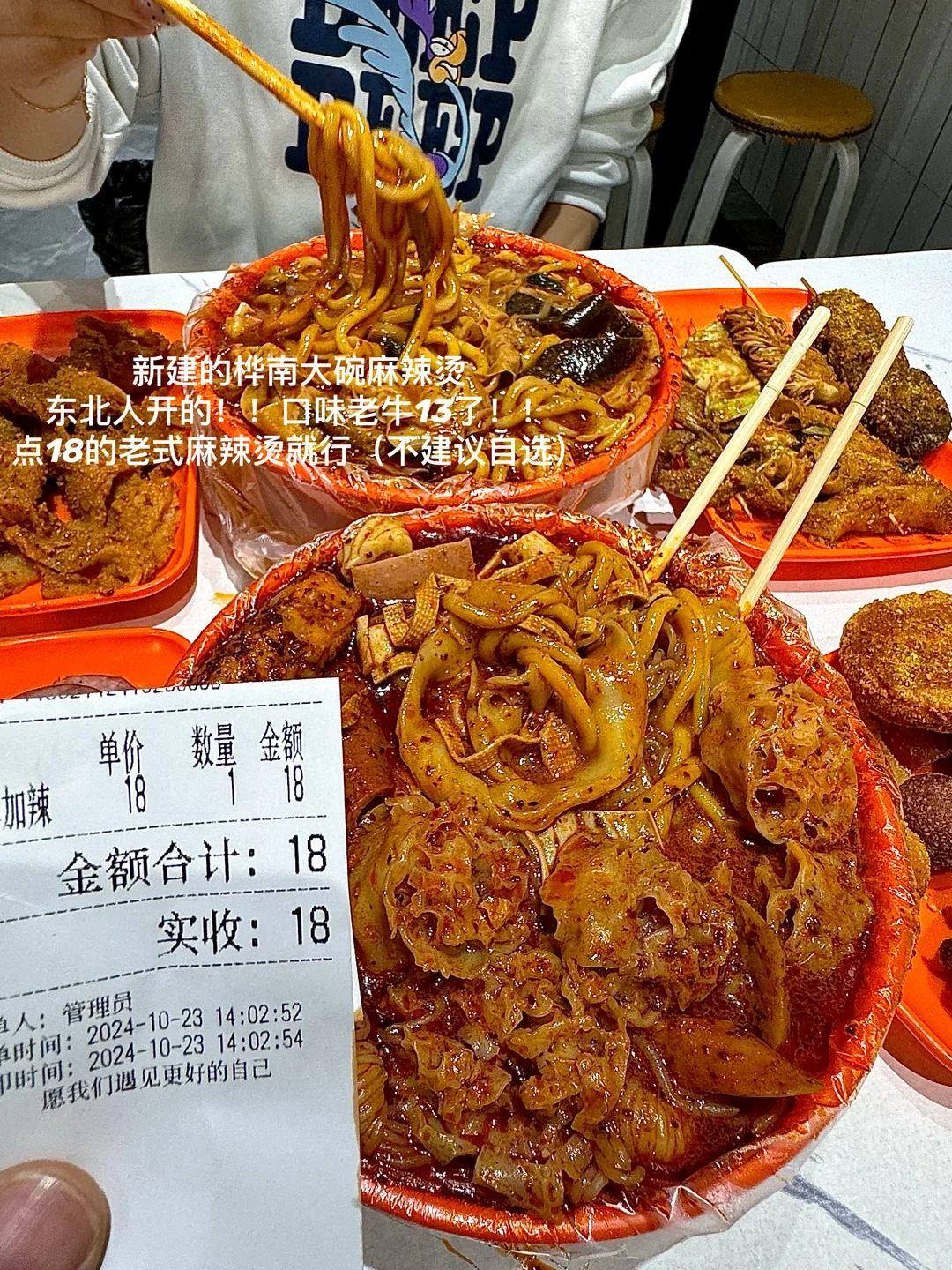 A large bowl of Nanchang malatang in chilli oil with a printed receipt for 18 yuan beside it