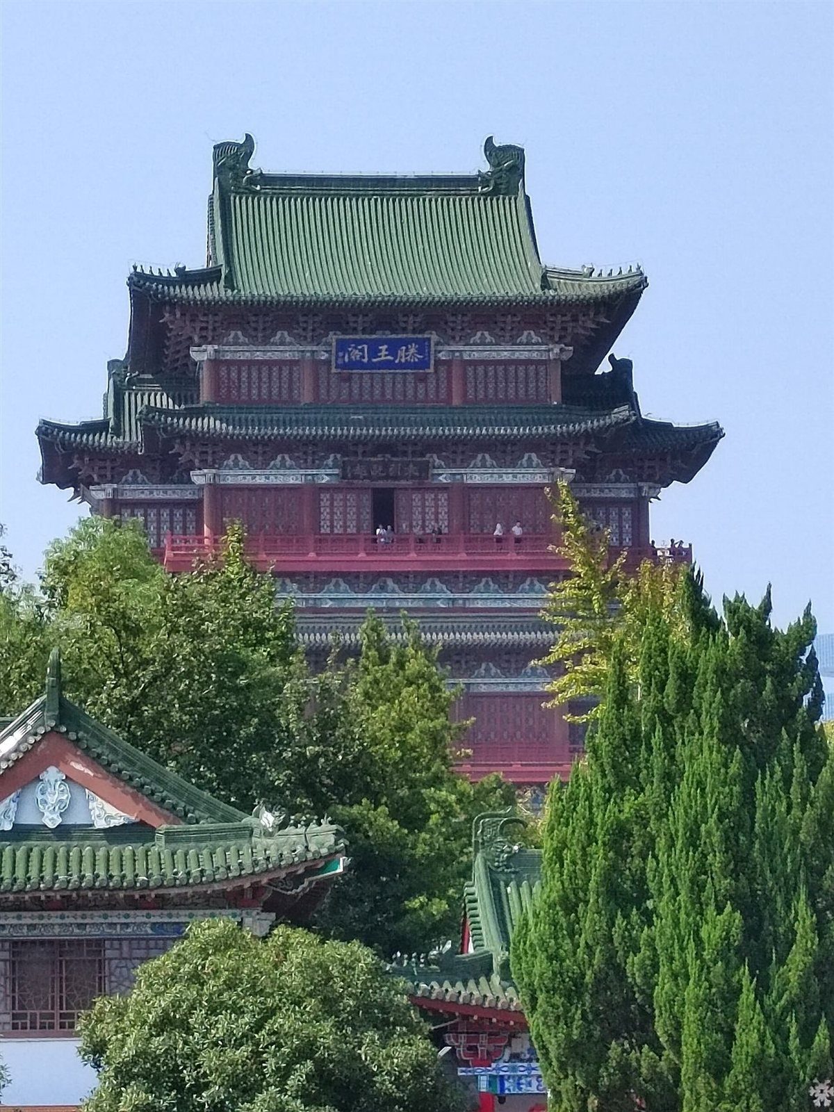 Close-up of Tengwang Pavilion's jade-green glazed roof tiles and upturned eave.